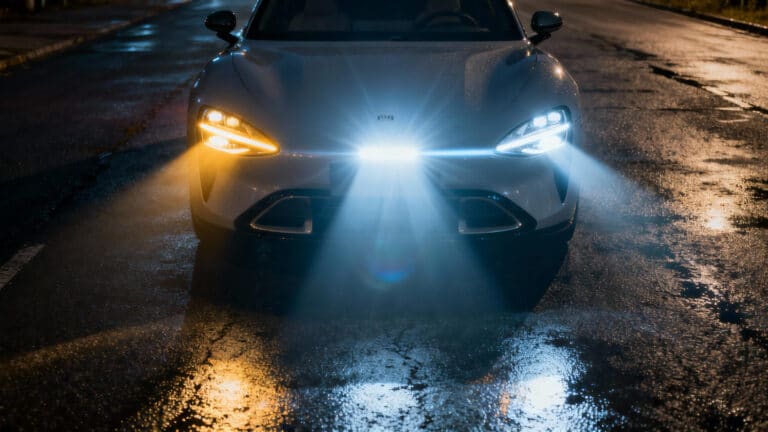 A complete headlight comparison showing the beam patterns of LED headlights, halogen headlights, and projector headlights on a modern car at night.